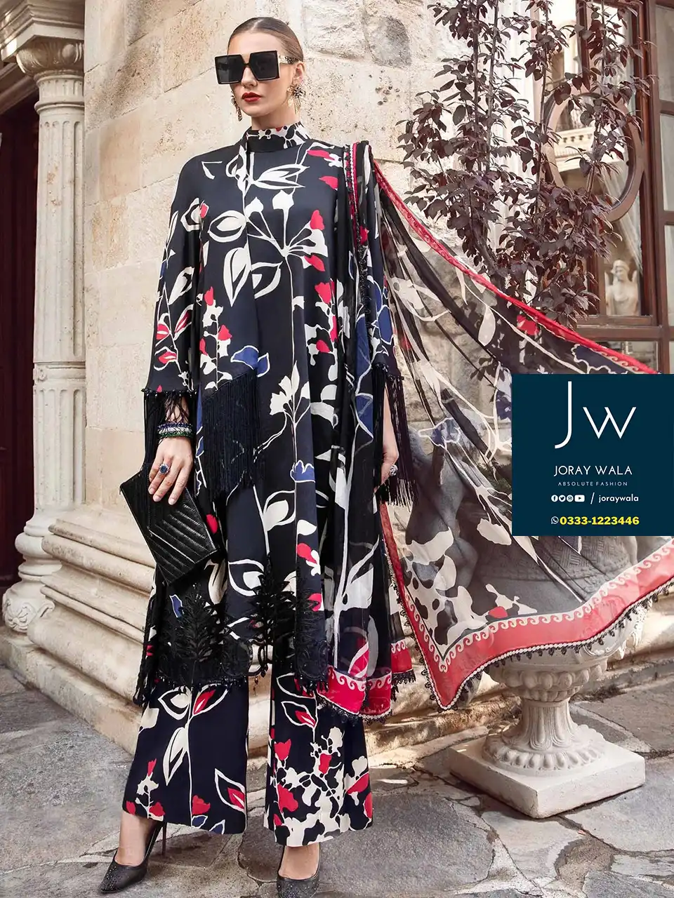 A model wearing a black floral and pattern design 3 pcs lawn embroidered suit and standing in a villa, and the suit code is MPT-2009-B