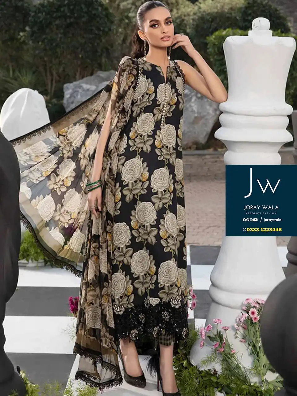 A Pakistani model wearing a Maria b fancy lawn collection suit and standing in the garden, the suit code is MPT-2103A/B-B-24