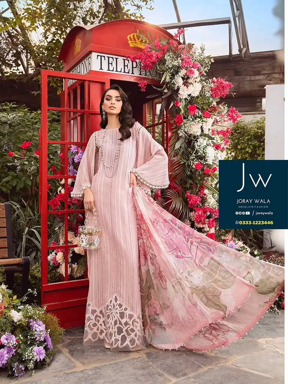 Model wearing a beautiful pink color 3 pcs suit and standing before red color telephone booth, a lot for flowers around the model, and the suit code is MPT-2109-A
