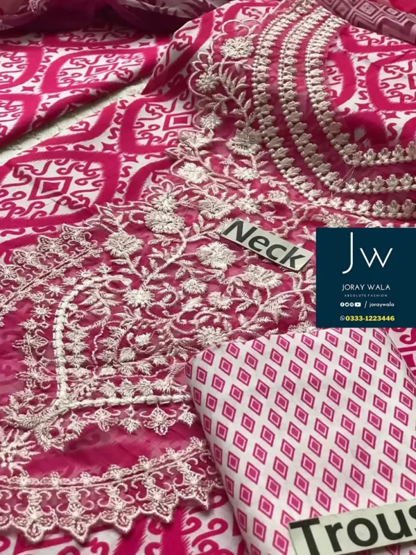 Woman in vibrant pink and white ethnic outfit with intricate patterns, posing gracefully outdoors. and this suit is available at joraywala